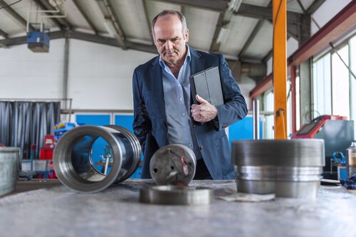 Engineer evaluating machined components in a workshop