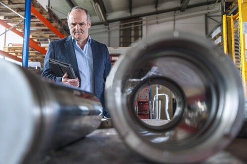 Engineer reviewing large machined components during workshop inspection