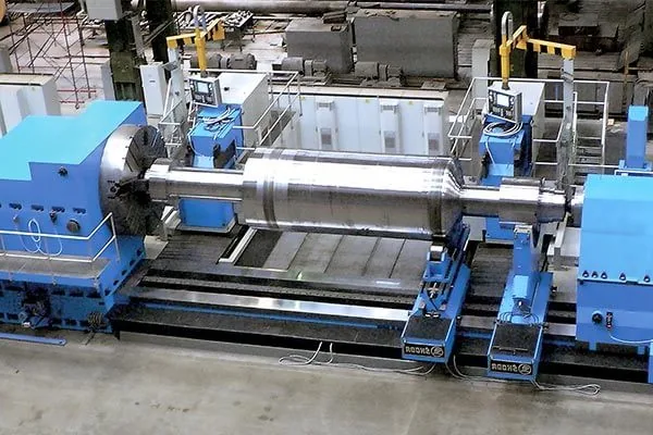Large horizontal lathe machining a heavy cylindrical workpiece