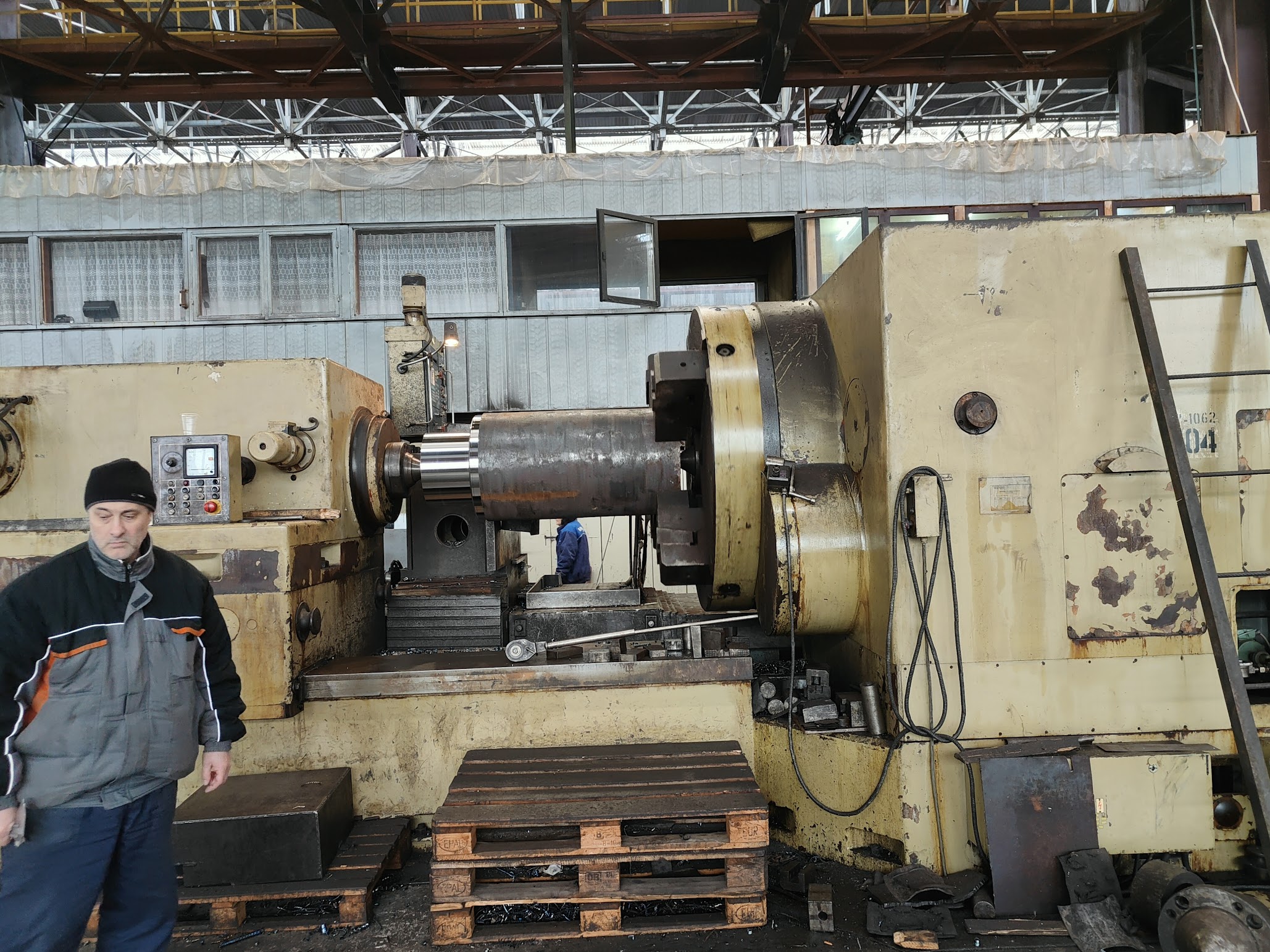 Heavy cylindrical workpiece during machining on a large lathe