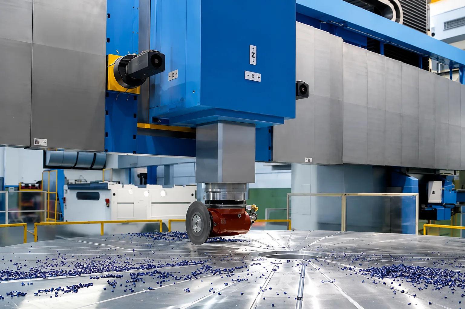 Close-up of a large CNC milling head working over a circular machine table