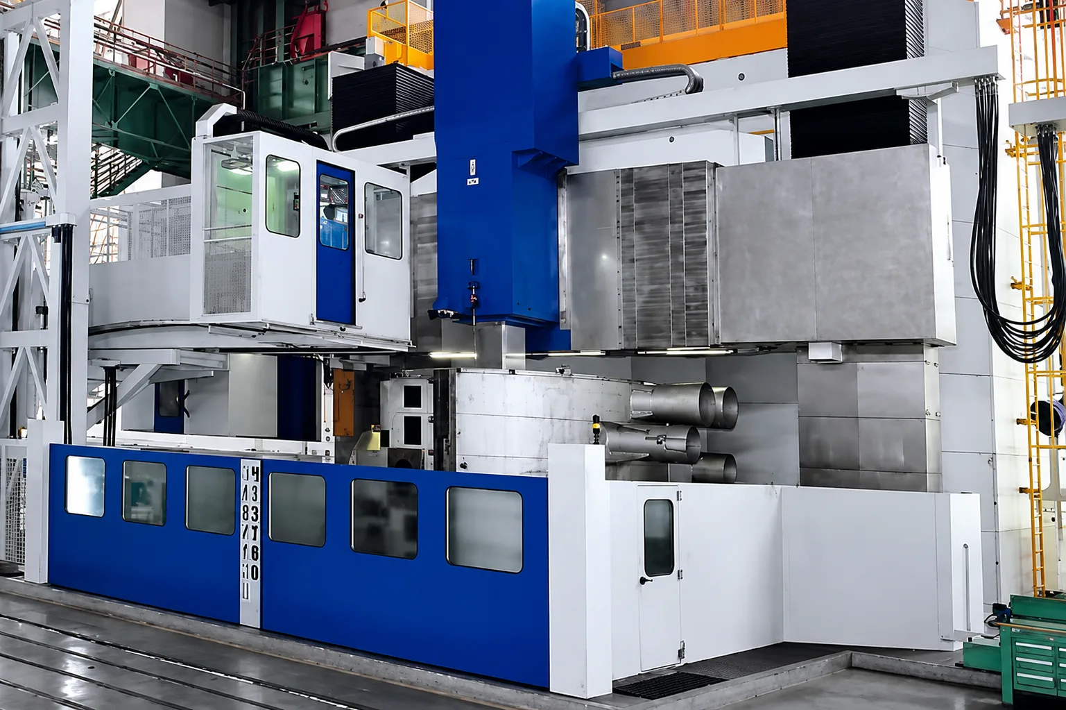 Large blue and white vertical turning machine in an industrial workshop