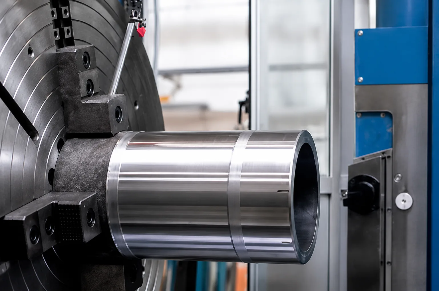 Close-up of a machined cylindrical part held in a large lathe chuck