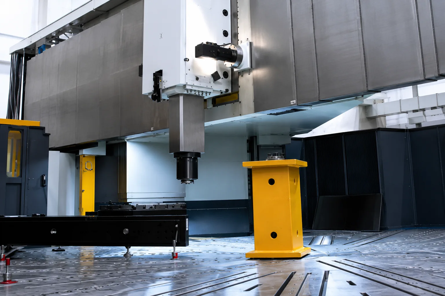 Large CNC turning machine head and table area with yellow fixture