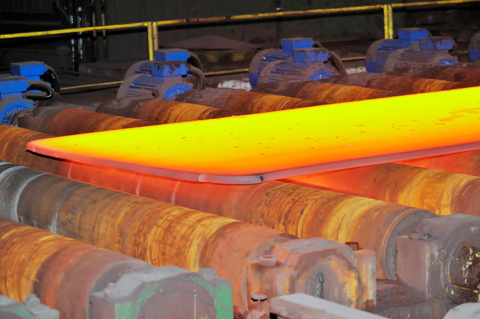 Hot steel slab moving through a rolling line