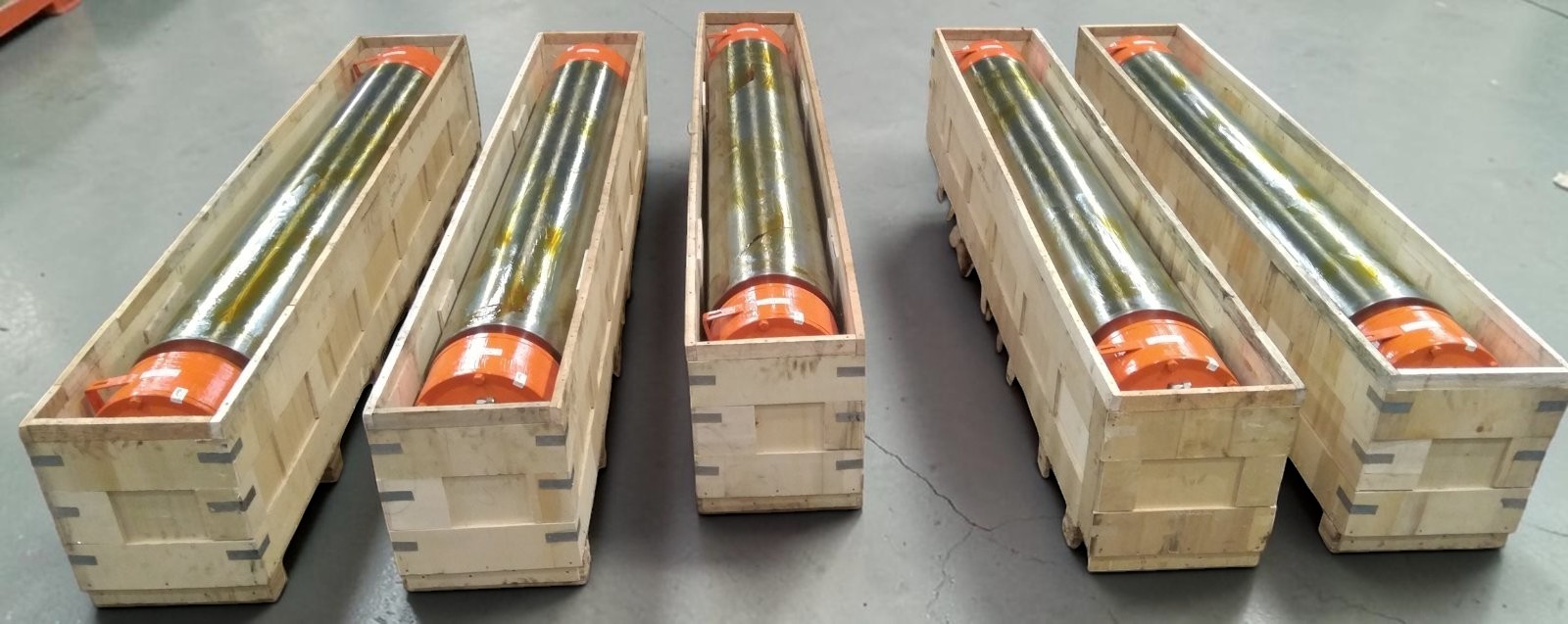Five finished rolling mill rolls protected in individual wooden shipping crates